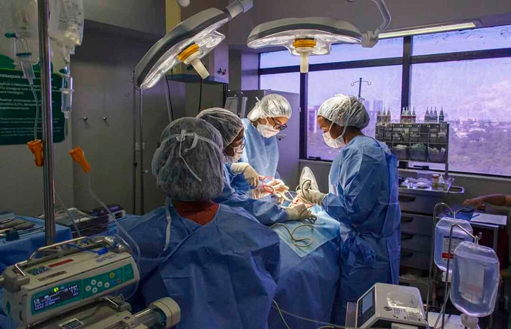 Dra. Vanessa Melo Bucomaxilofacial - Doutora e equipe de três profissionais executando cirurgia em bloco cirúgico.